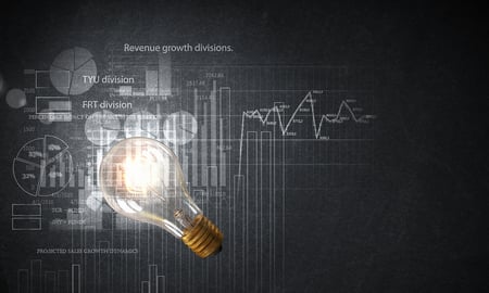 Glowing glass light bulb hanging from above and business sketches at dark background Glowing glass light bulb hanging from above and business sketches at dark background
